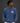 A man wearing a washed blue crewneck sweatshirt with a white graphic print on the left chest that reads 'GOOD QUALITY HUMAN' and 'EST. 2024'.